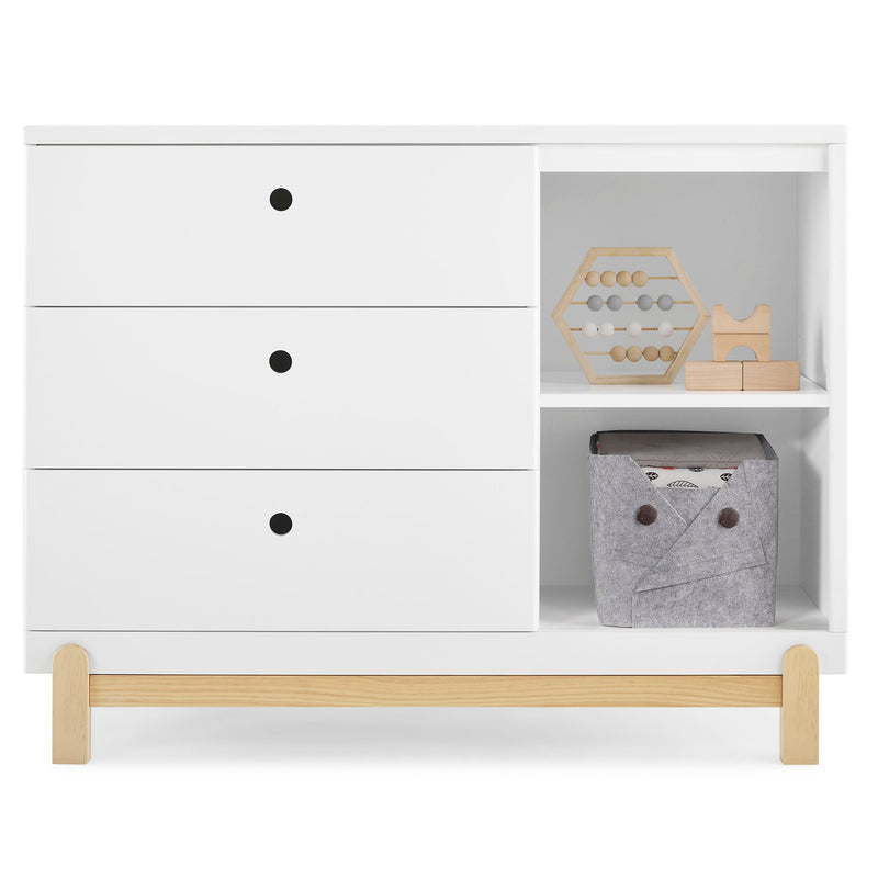 White dresser with wooden accents and shelves containing toys and a gray storage box.