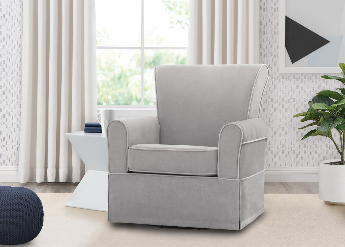 Gray armchair in a living room with white curtains and a plant.