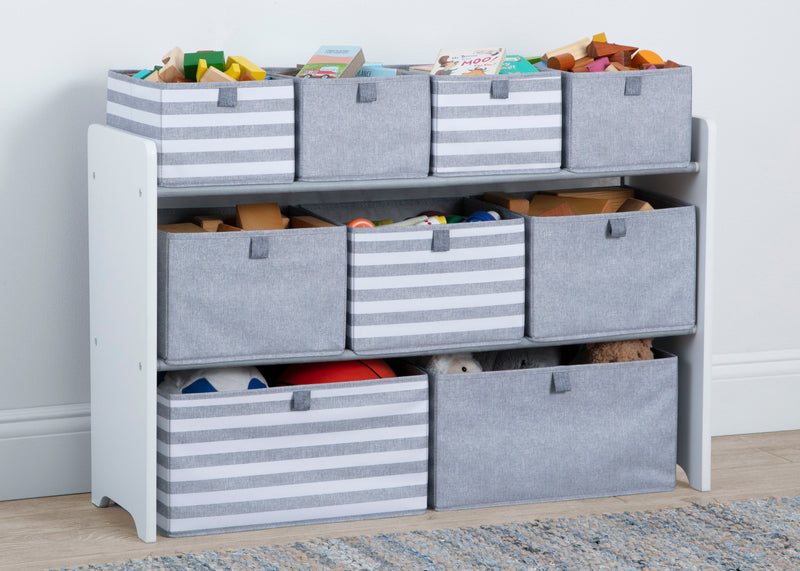 Storage unit with gray bins and colorful toys on a wooden floor.