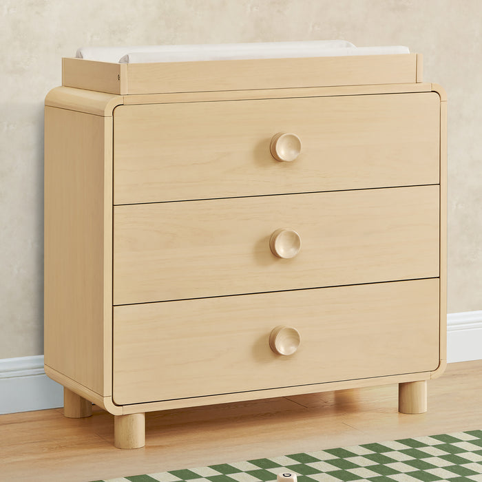 Beige dresser with three drawers in a room setting 0-Ari 3 Drawer Dresser with Changing Top