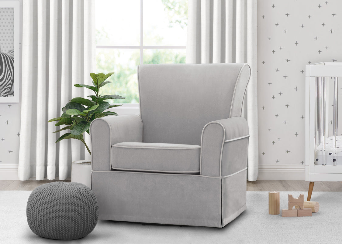 Gray armchair in a room with white walls, a plant, and toys.